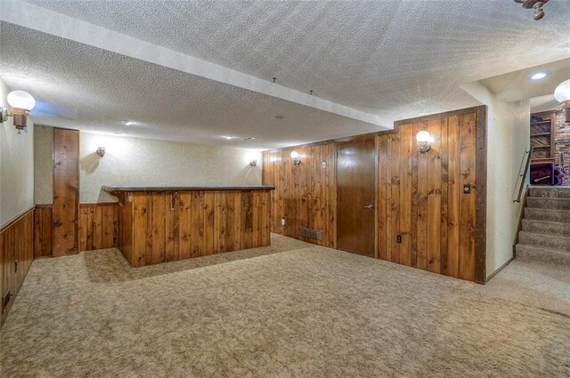 16327 W Locust St, Olathe, KS 66062 - finished below grade area with wood walls, carpet flooring, a textured ceiling, stairway, and a wainscoted wall