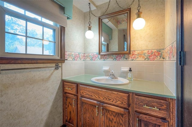 16327 W Locust St, Olathe, KS 66062 - bathroom with vanity, a wainscoted wall, tile walls, and wallpapered walls