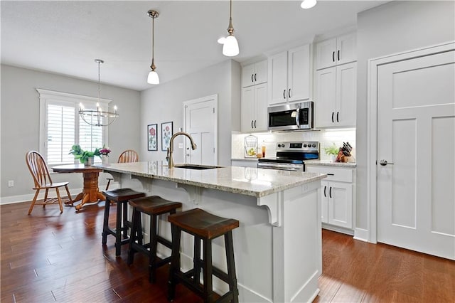 23103 W 125th Ter, Olathe, KS 66016 - kitchen featuring stainless steel appliances, backsplash, a center island with sink, a chandelier, and a breakfast bar