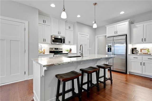 23103 W 125th Ter, Olathe, KS 66016 - kitchen with appliances with stainless steel finishes, tasteful backsplash, white cabinetry, pendant lighting, and a kitchen bar