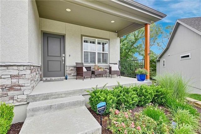 23103 W 125th Ter, Olathe, KS 66016 - view of exterior entry featuring a porch, stone siding, and stucco siding