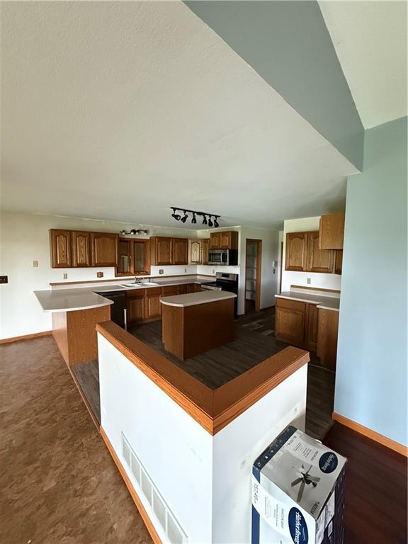 1011 N Arrowhead Dr, Burlington, KS 66839 - kitchen featuring a kitchen island, stainless steel appliances, and brown cabinetry