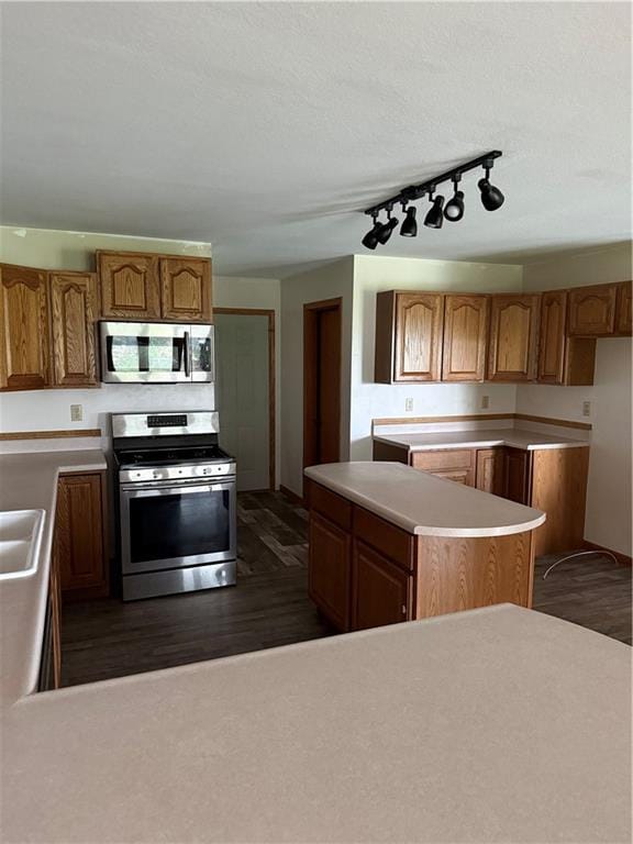 1011 N Arrowhead Dr, Burlington, KS 66839 - kitchen featuring appliances with stainless steel finishes, track lighting, dark wood finished floors, light countertops, and brown cabinets