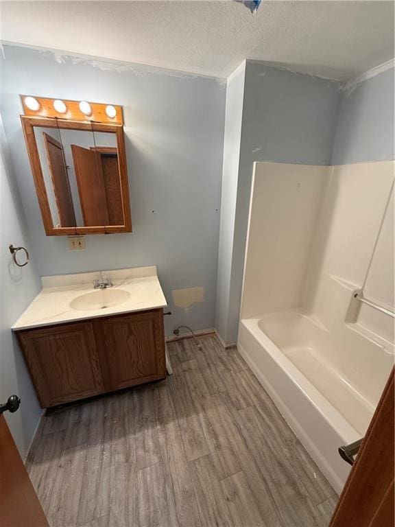 1011 N Arrowhead Dr, Burlington, KS 66839 - bathroom with wood finished floors, vanity, a textured ceiling, and bathtub / shower combination