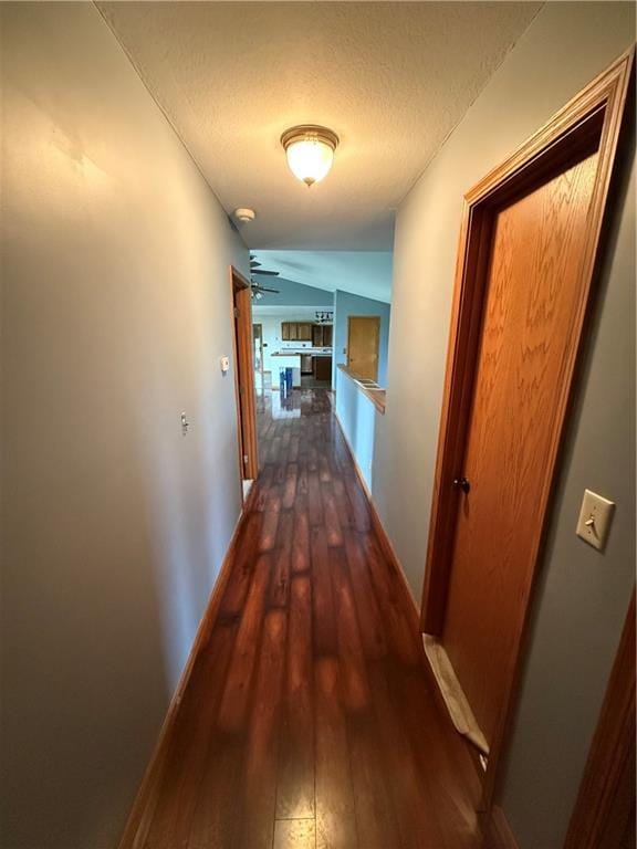 1011 N Arrowhead Dr, Burlington, KS 66839 - hallway with dark wood-style flooring, a textured ceiling, and vaulted ceiling
