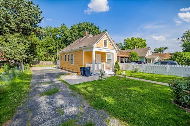 321 Oakley Ave, Kansas City, MO 64123 - view of front facade with driveway, covered porch, and a chimney