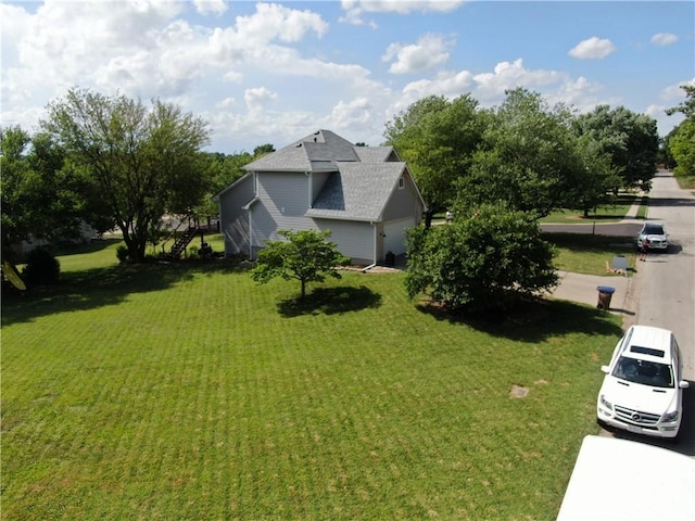 200 S Park Dr, Raymore, MO 64083 - view of home's exterior featuring a yard and roof with shingles