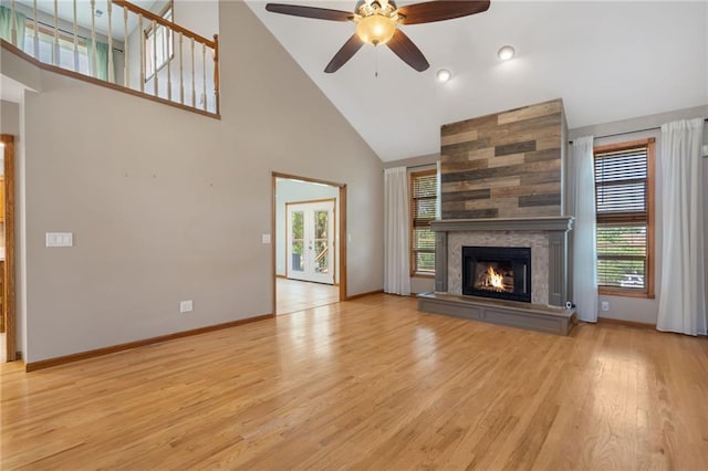 200 S Park Dr, Raymore, MO 64083 - unfurnished living room featuring high vaulted ceiling, ceiling fan, a tile fireplace, and wood finished floors