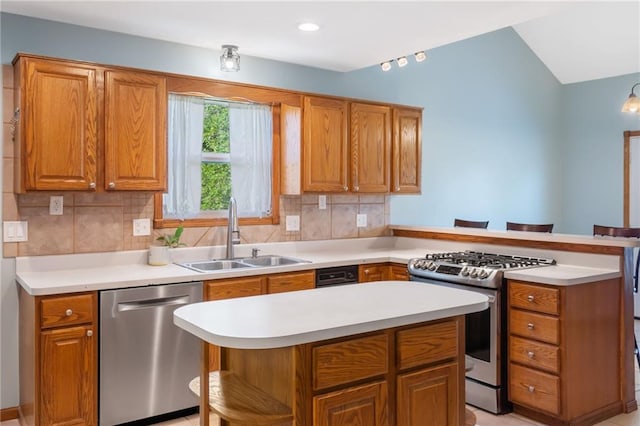 200 S Park Dr, Raymore, MO 64083 - kitchen featuring stainless steel appliances, a peninsula, light countertops, decorative backsplash, and brown cabinetry