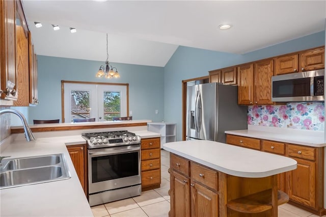 200 S Park Dr, Raymore, MO 64083 - kitchen featuring appliances with stainless steel finishes, brown cabinetry, light tile patterned flooring, lofted ceiling, and light countertops