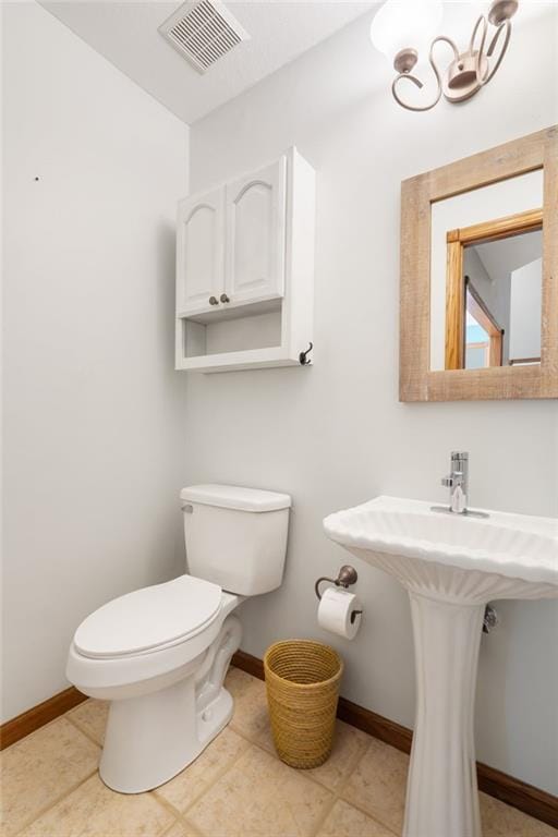 200 S Park Dr, Raymore, MO 64083 - half bath featuring toilet and a chandelier