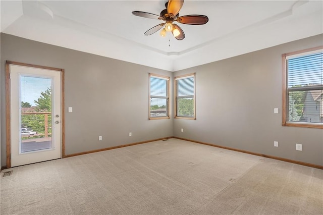 200 S Park Dr, Raymore, MO 64083 - unfurnished room featuring plenty of natural light, a raised ceiling, light carpet, and ceiling fan