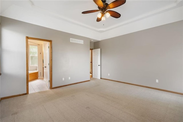 200 S Park Dr, Raymore, MO 64083 - carpeted spare room featuring a raised ceiling and ceiling fan