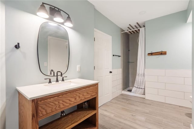 200 S Park Dr, Raymore, MO 64083 - bathroom with a shower stall, vanity, and wood finished floors