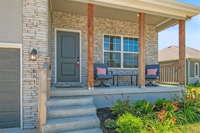 801 NW Hickory Ridge Dr, Grain Valley, MO 64029 - view of exterior entry featuring covered porch, stone siding, and a garage