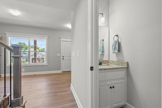 801 NW Hickory Ridge Dr, Grain Valley, MO 64029 - bathroom featuring wood finished floors, vanity, and a textured ceiling