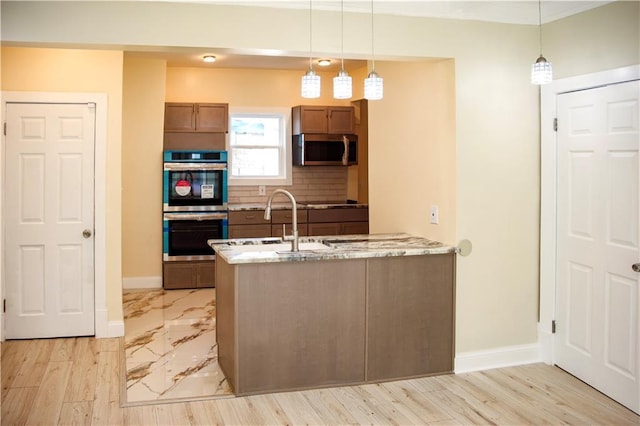 3635 Wabash Ave, Kansas City, MO 64109 - kitchen with appliances with stainless steel finishes, brown cabinets, light stone countertops, decorative backsplash, and decorative light fixtures