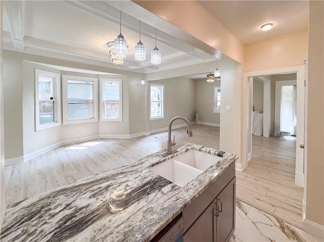 3635 Wabash Ave, Kansas City, MO 64109 - kitchen featuring open floor plan, light stone countertops, hanging light fixtures, light wood-style floors, and a ceiling fan