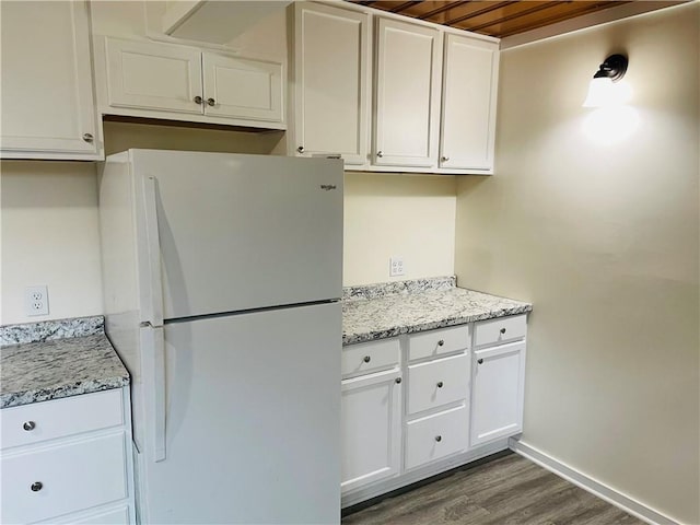 812 N 9th St, Leavenworth, KS 66048 - kitchen with freestanding refrigerator, dark wood-style floors, white cabinetry, and light stone counters