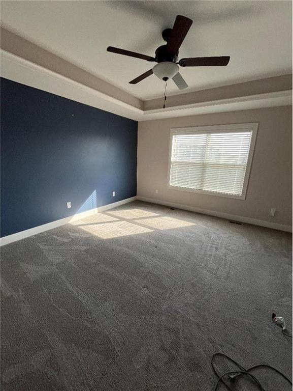 15653 Lakeside Dr, Basehor, KS 66007 - carpeted spare room with a tray ceiling and a ceiling fan