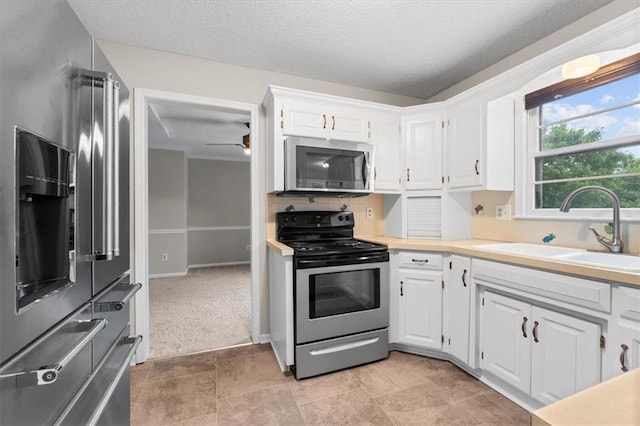 13942 W 113th St, Olathe, KS 66215 - kitchen with appliances with stainless steel finishes, white cabinetry, light countertops, a ceiling fan, and tasteful backsplash