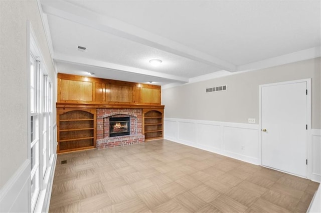 13942 W 113th St, Olathe, KS 66215 - unfurnished living room with beam ceiling, a decorative wall, a brick fireplace, and a wainscoted wall
