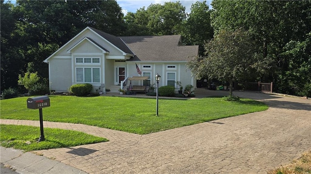 16810 NE 170th Ter, Holt, MO 64048 - view of front of house featuring a front lawn, stucco siding, curved driveway, and view of wooded area