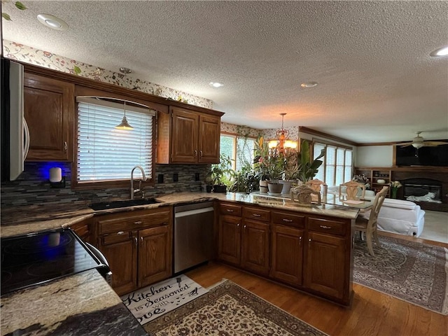 505 Williamsburg Dr, Lees Summit, MO 64063 - kitchen with dishwasher, electric range, a textured ceiling, light wood finished floors, and a peninsula