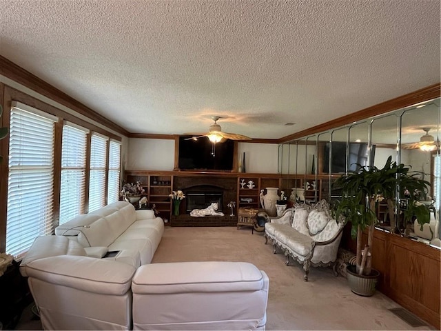 505 Williamsburg Dr, Lees Summit, MO 64063 - living room featuring ceiling fan, carpet flooring, a textured ceiling, ornamental molding, and a fireplace with raised hearth