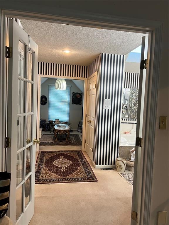 505 Williamsburg Dr, Lees Summit, MO 64063 - hallway with carpet flooring, a textured ceiling, french doors, and wallpapered walls