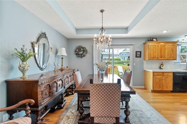 1903 NW Rosewood Dr, Grain Valley, MO 64029 - dining room featuring a chandelier, healthy amount of natural light, light wood-type flooring, and a textured ceiling