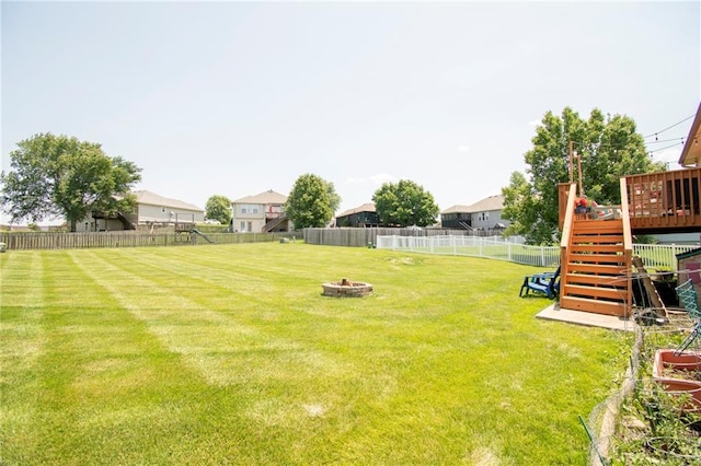1903 NW Rosewood Dr, Grain Valley, MO 64029 - fenced backyard featuring stairway, an outdoor fire pit, and a wooden deck