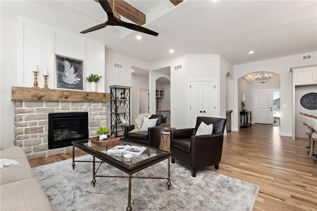 15323 W 171st Ter, Olathe, KS 66062 - living room featuring arched walkways, light wood-style floors, a ceiling fan, recessed lighting, and a stone fireplace