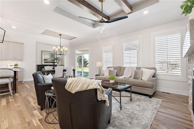 15323 W 171st Ter, Olathe, KS 66062 - living room featuring light wood-type flooring, a chandelier, beamed ceiling, ceiling fan, and a raised ceiling