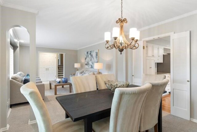 5501 W 86th St, Overland Park, KS 66207 - dining room featuring a chandelier, ornamental molding, light colored carpet, and arched walkways