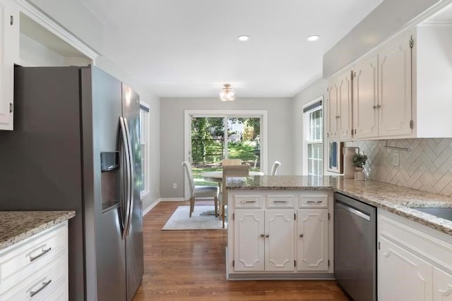 5501 W 86th St, Overland Park, KS 66207 - kitchen featuring stainless steel appliances, a peninsula, white cabinets, dark wood-style floors, and decorative backsplash