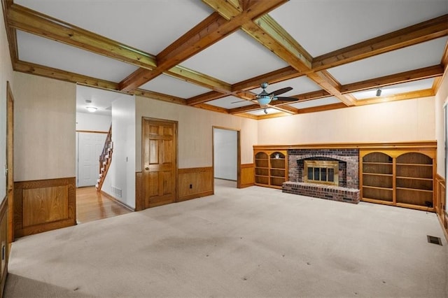 13217 S Locust St, Olathe, KS 66062 - unfurnished living room featuring carpet, beam ceiling, a wainscoted wall, coffered ceiling, and a ceiling fan