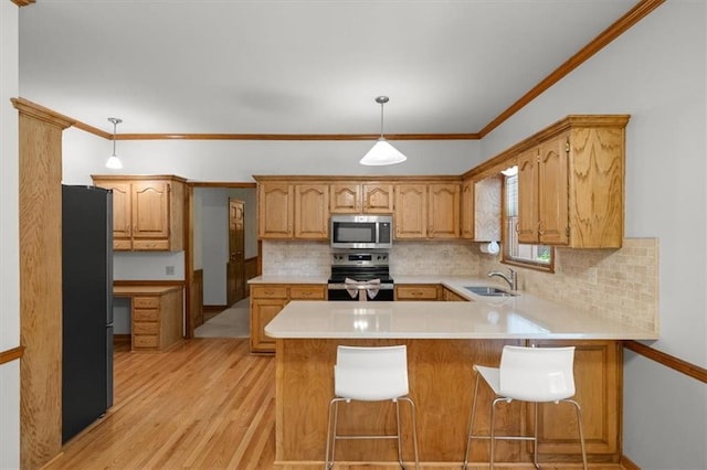 13217 S Locust St, Olathe, KS 66062 - kitchen featuring stainless steel appliances, a peninsula, light wood finished floors, backsplash, and light countertops