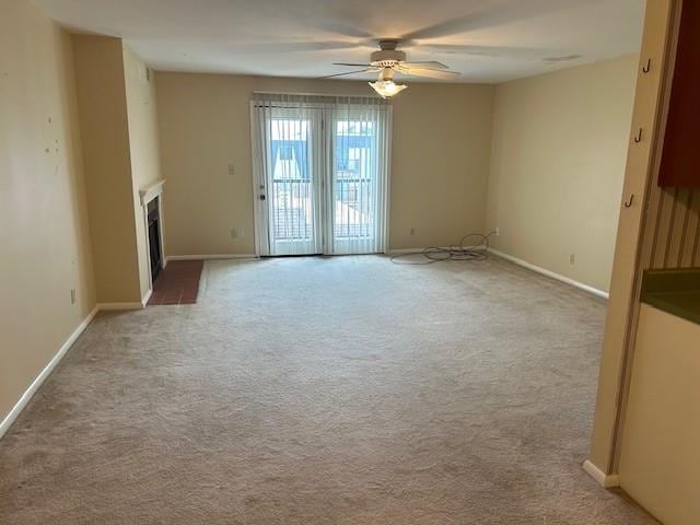 3600 Gabriel Ave Unit 303, Parsons, KS 67357 - unfurnished living room featuring a ceiling fan, light colored carpet, and a fireplace