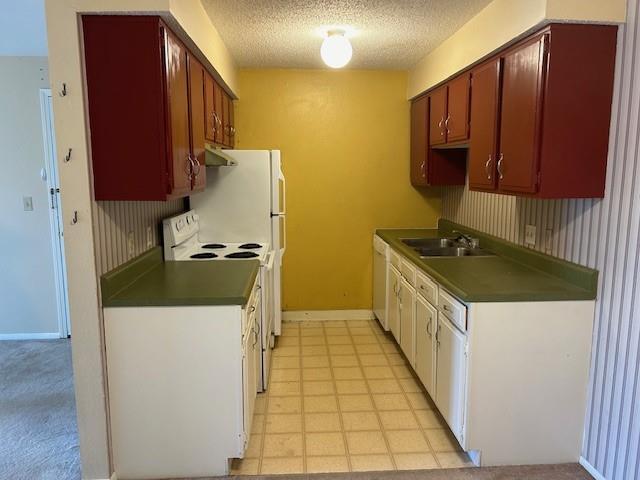 3600 Gabriel Ave Unit 303, Parsons, KS 67357 - kitchen with white appliances, dark countertops, a textured ceiling, and exhaust hood
