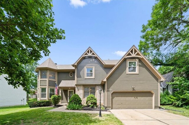 14522 W 61st St, Shawnee, KS 66216 - view of front of property with an attached garage, a front yard, and concrete driveway