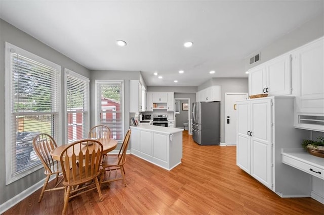 14522 W 61st St, Shawnee, KS 66216 - kitchen with appliances with stainless steel finishes, light wood-style flooring, a peninsula, white cabinetry, and recessed lighting