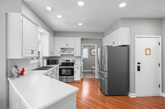 14522 W 61st St, Shawnee, KS 66216 - kitchen featuring stainless steel appliances, a peninsula, light countertops, white cabinetry, and recessed lighting