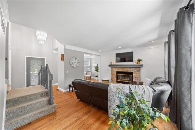 14522 W 61st St, Shawnee, KS 66216 - living area featuring light wood finished floors, a chandelier, stairs, a fireplace, and recessed lighting