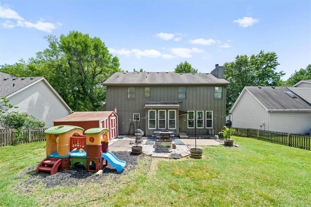 14522 W 61st St, Shawnee, KS 66216 - back of property featuring a patio, board and batten siding, a fenced backyard, a chimney, and a fire pit