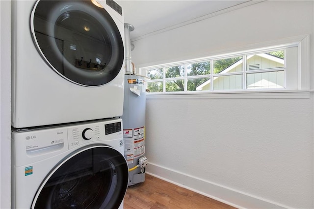 217 W 9th St, Ottawa, KS 66067 - washroom featuring stacked washer / dryer, gas water heater, wood finished floors, plenty of natural light, and crown molding