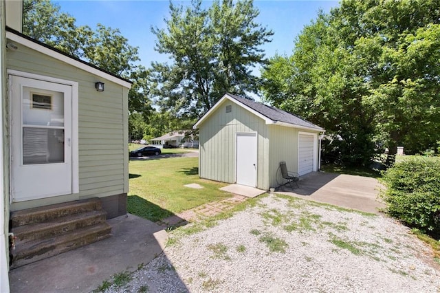 217 W 9th St, Ottawa, KS 66067 - view of grassy yard featuring entry steps, an outdoor structure, a garage, and driveway