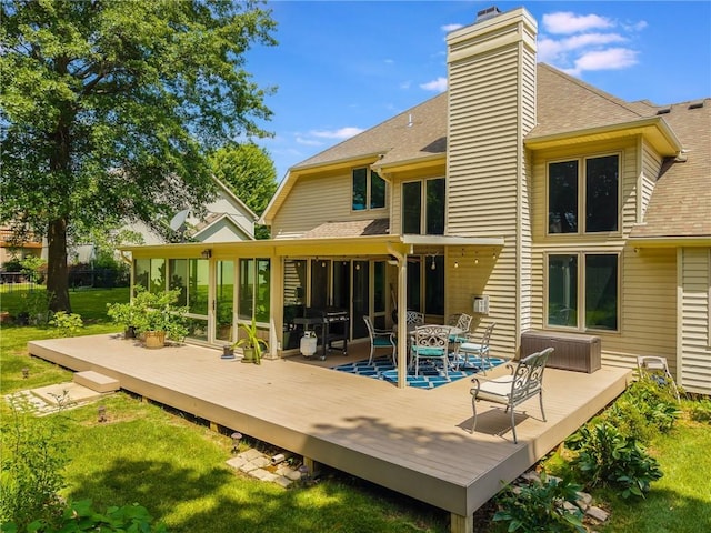 4902 Corinth Dr, Saint Joseph, MO 64506 - back of property with a shingled roof, a sunroom, and a deck
