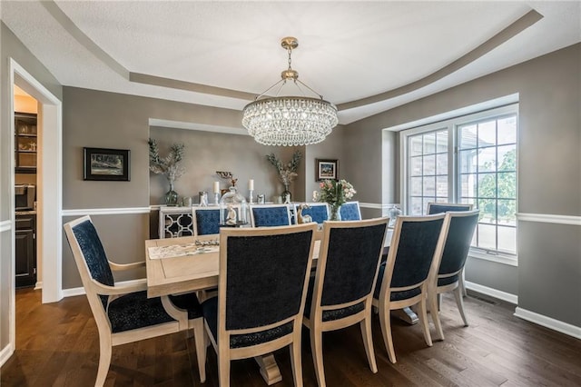 4902 Corinth Dr, Saint Joseph, MO 64506 - dining room featuring a tray ceiling, wood finished floors, and a chandelier