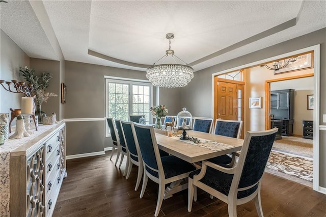 4902 Corinth Dr, Saint Joseph, MO 64506 - dining space with a chandelier, a tray ceiling, a textured ceiling, and dark wood-style flooring